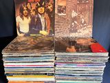a stack of vinyl records sitting on top of a blue table