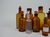 several brown glass bottles are lined up on a white surface