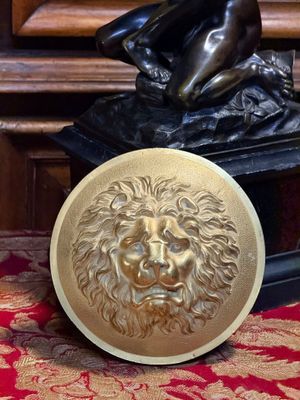 une statue représentant un homme à tête de lion, posée sur une plaque