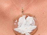a close up of a woman wearing a necklace with an angel on it