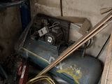 a pile of junk in a garage with a blower and other items
