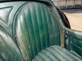 a close up of a green leather seat in the back of a car