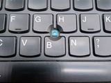 a close up of a computer keyboard with a blue button