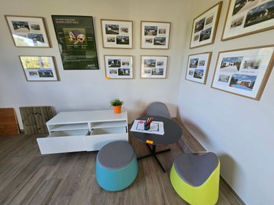 a room with a table, chairs, and pictures on the wall