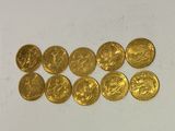 a bunch of gold coins sitting on top of a white surface