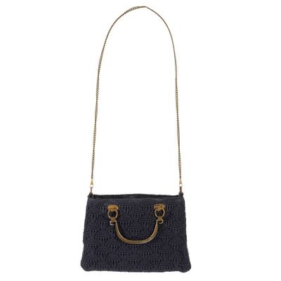 a black crocheted bag with a gold handle