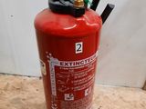 a fire extinguisor sitting on the floor next to a wall
