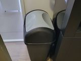 two trash cans sitting next to each other on the floor