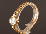 a close up of a watch on a stand with a black background