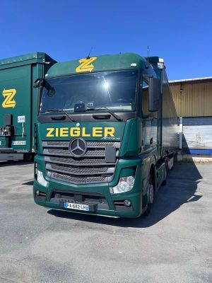 un camion vert garé sur un parking