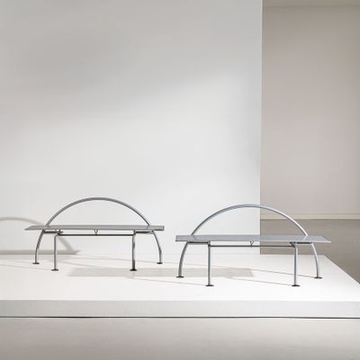 two benches on a white platform in a room with a white wall