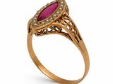 a gold ring with a ruby stone and diamonds