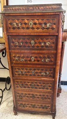 a wooden chest of drawers with a mirror in the background