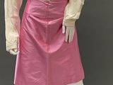 mannequin dressed in a pink skirt and beige blouse with ruffles