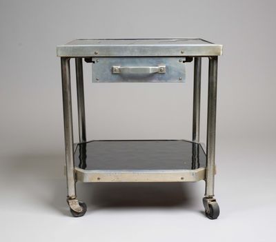 an old metal table with a drawer on top of it