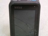 a small black camera with a broken screen sitting on a table