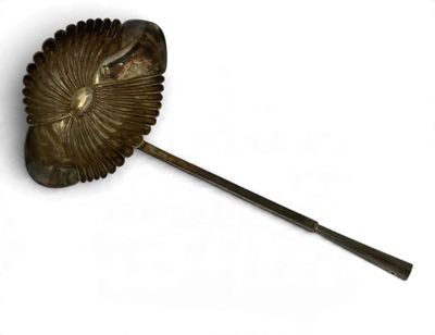 un objet métallique qui ressemble à une feuille au bout d'un bâton