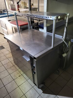 une table de travail en acier inoxydable au milieu d'une cuisine
