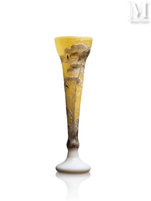 un vase en verre avec un tableau posé sur une table
