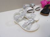 several pairs of children ' s shoes are lined up on a table