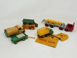 four toy trucks and a tractor on a white surface