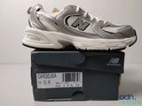 des chaussures New Balance toutes neuves, dans leur boîte, posées sur la table, avec leur étiquette de prix