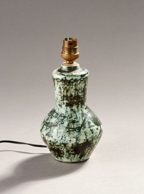 a green and white lamp with a black cord on top of it