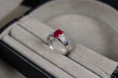 a ring with a red stone in it in a box
