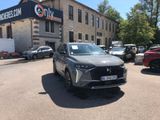 the front view of a silver suv parked in front of a building