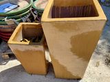 a large yellow planter sitting on the ground next to a pile of trash