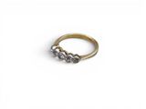 a close up of a gold ring with three diamonds on it
