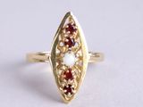 an image of a gold ring with a red and white stone
