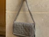 un sac à main accroché au mur, auquel est fixé un téléphone