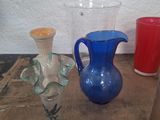 several different colored glass vases are sitting on a wooden table