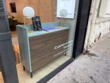 a small desk in the window of a store