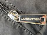 the zipper of a black bag with a metal clasp on it