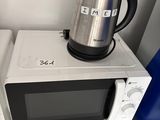 un micro-ondes et une bouilloire posée sur le micro-ondes