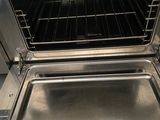 an open oven with a metal pan inside of it