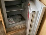 a small open safe box in the corner of a kitchen
