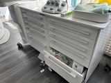 a white medical cart with drawers and a tray on top of it