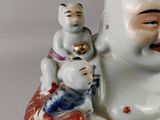a figurine of a man holding a baby and a cat