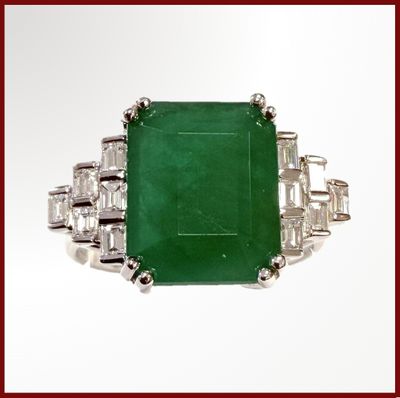une bague en émeraude et diamants, ornée de diamants taille baguette sur fond blanc