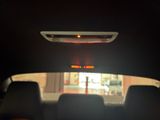 a rear view mirror of a car with a red light on