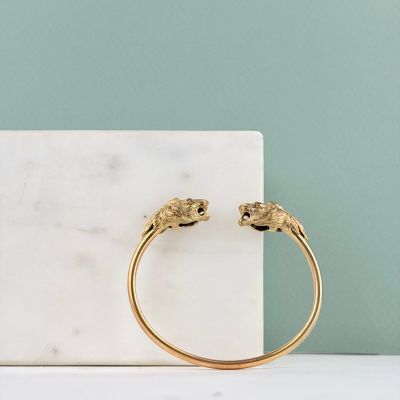 Le bracelet manchette en or est orné de deux petits éléphants