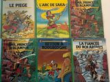 several children ' s books are lined up on a white surface