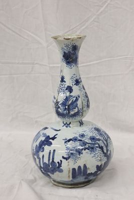 un vase bleu et blanc posé sur une surface blanche