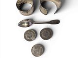 a spoon, spoon rest, and two silver spoons on a white surface