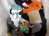 a pile of clothes and books in a trash can