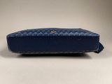 a close up of a blue purse on a white surface
