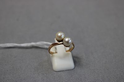 un gros plan d'une bague ornée de deux perles